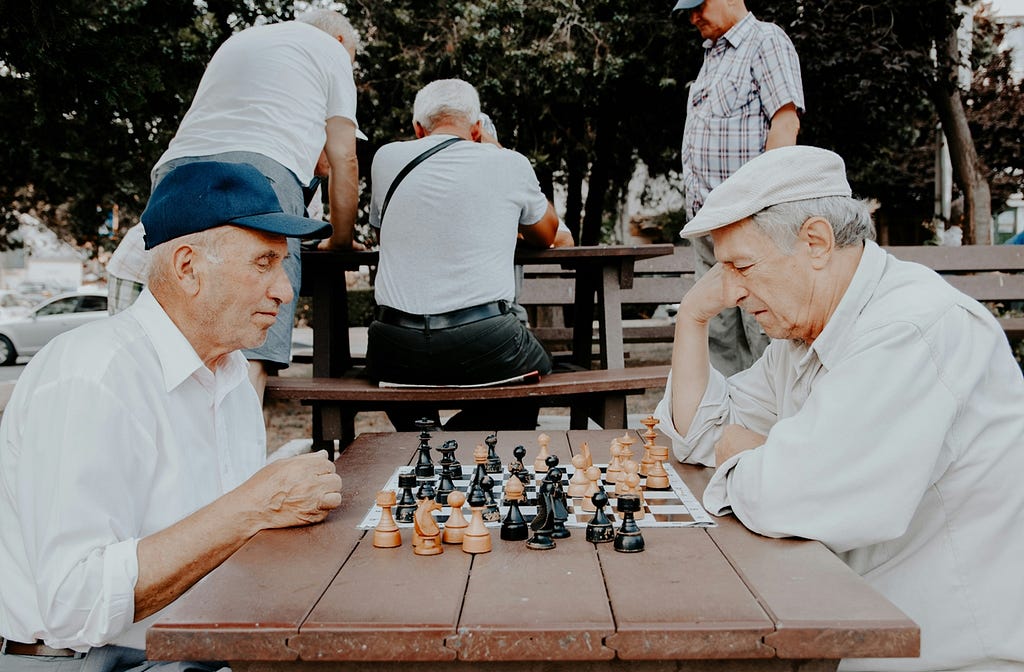 Two older men playing chess