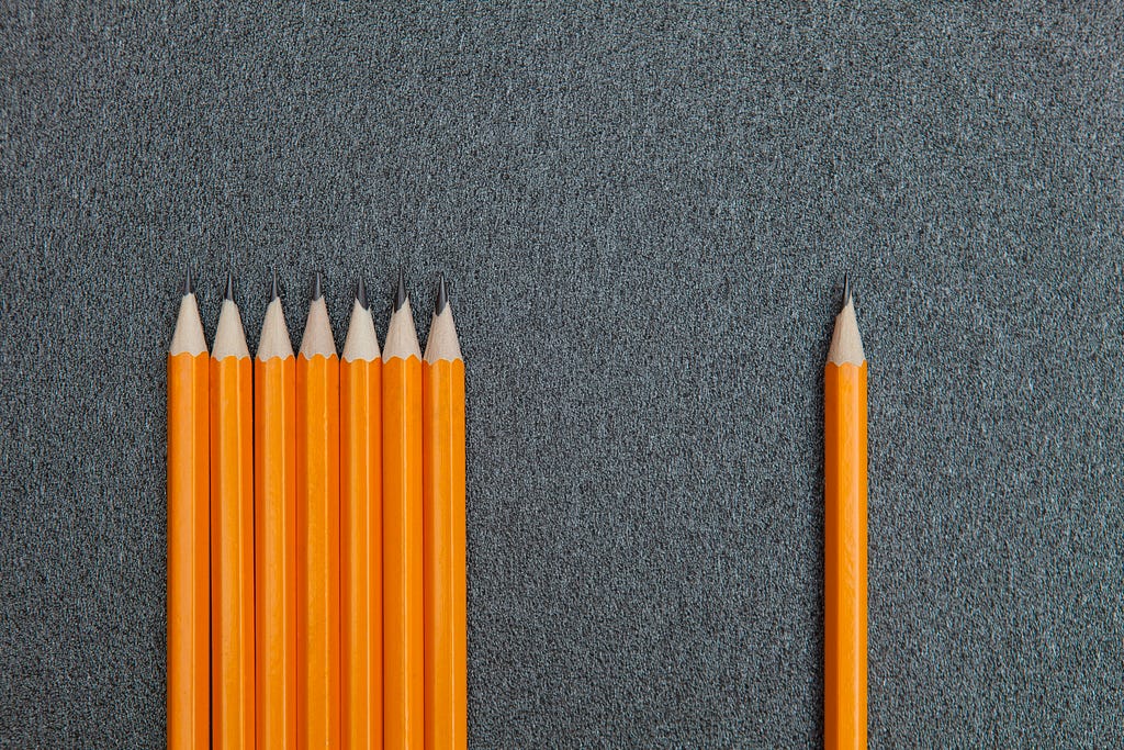 Several pencils together on the left and one pencil alone on the right
