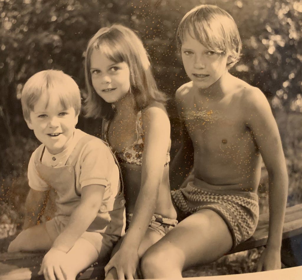 Sepia image of 7-year-old LeighAnn with brothers in Dad’s backyard