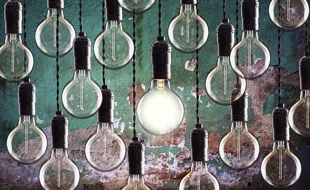 Decorative image of light bulbs hanging from strings against a green background. Only one of the bulbs is on.