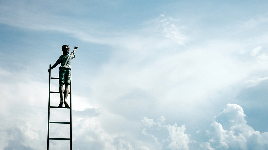 boy climbing up a ladder, reaching up to the sky, and touching it
