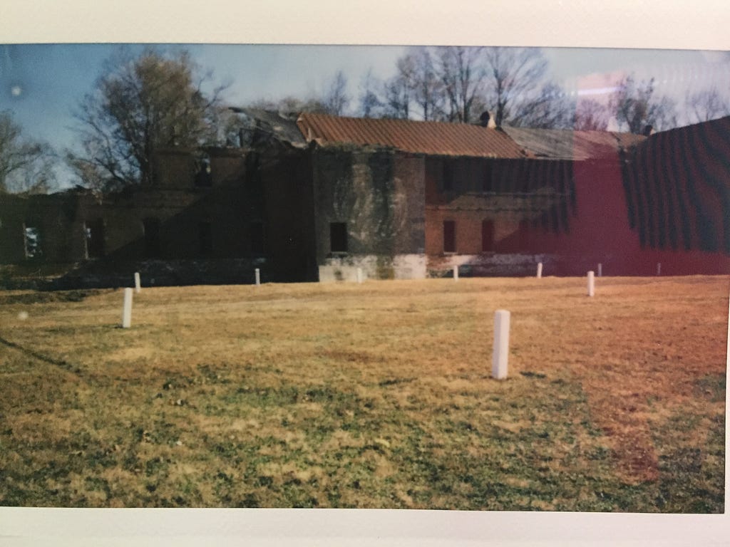 The burial location of William Lanigan and countless other New Yorkers. Each white pillars represents about 150 individuals. Behind the pillars was the Pheonix Rehab facility, which functioned in the 1970’s. Photography by the author courtesy of a Correction Officer’s generosity and Polaroid camera.