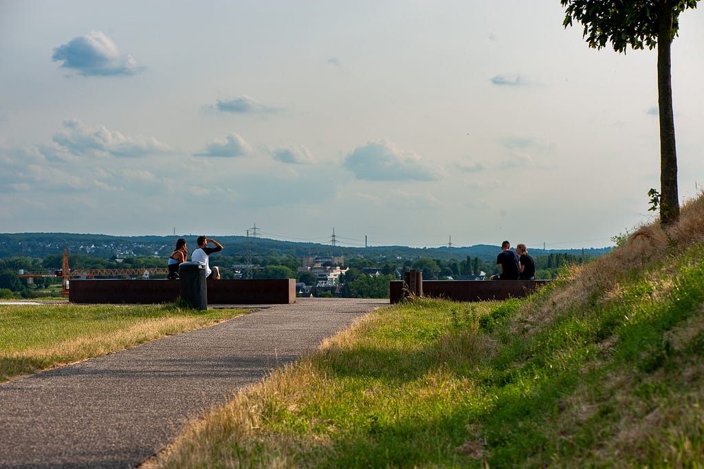 Two couples sit on benches atop the mound Kaiserberg. Dortmund, Germany, June 30, 2023.