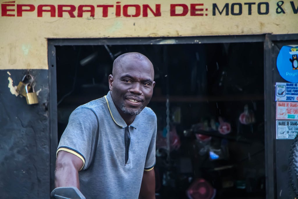 A man sitting outside an auto repair shop