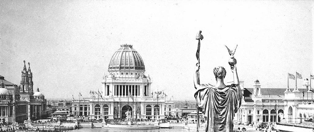 A large domed structure opposite a colossal statue.