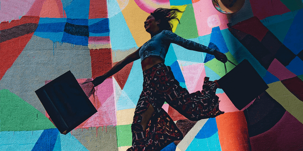 Happy vibrant woman with shopping bags and a colorful background