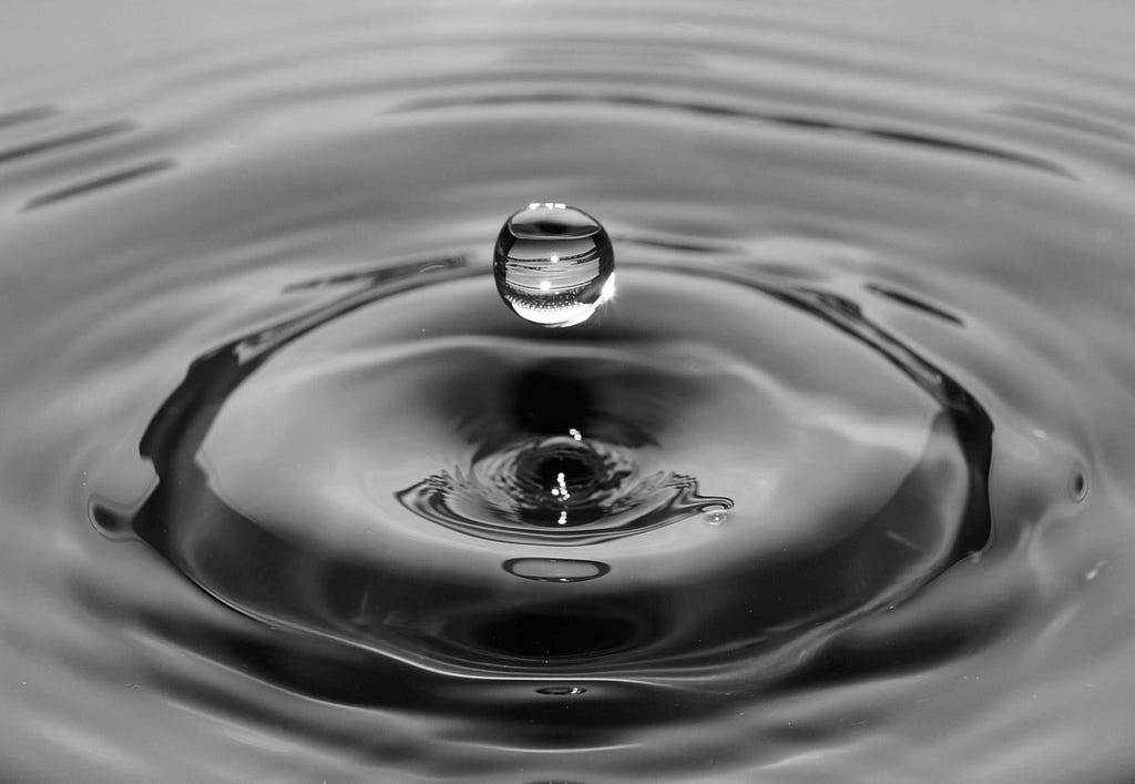 Black & white ripples and droplet on water