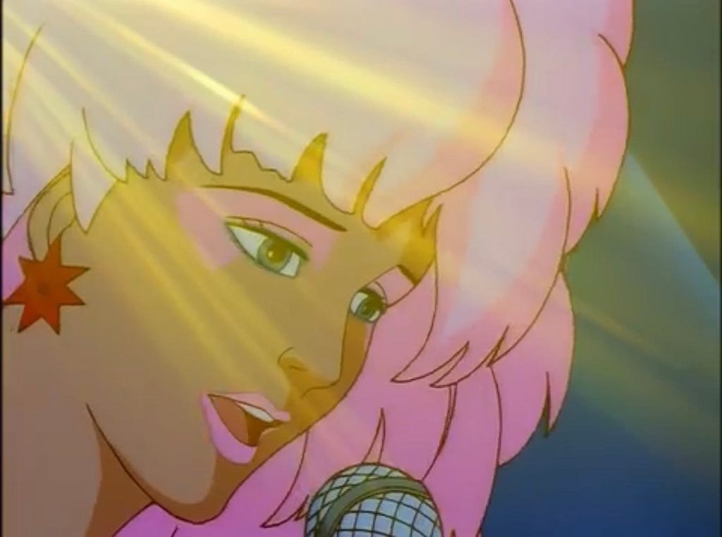 Screenshot of Jem from the 1985 cartoon show Jem and the Holograms. A white woman with pink hair and red star earrings is singing into a microphone.