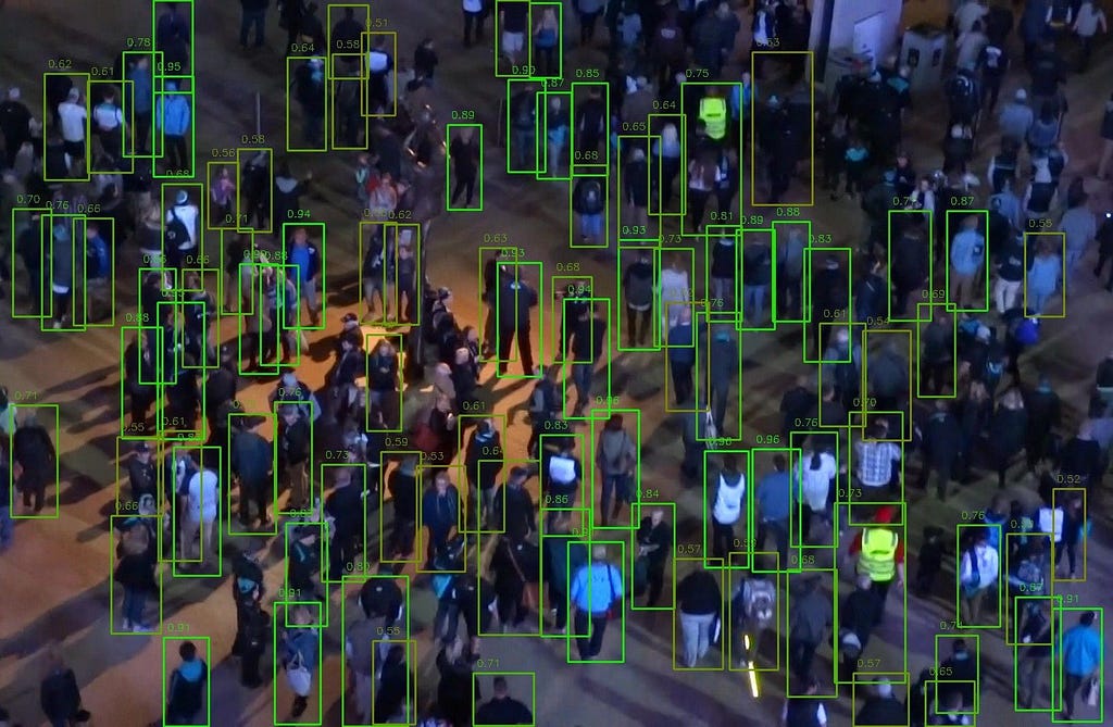 La photographie d’une foule en extérieur montrée précédemment. Les personnes ne sont pas toutes détectées, mais beaucoup plus le sont que dans la première photographie. Ce modèle détecte un peu plus de personnes que le précédent.