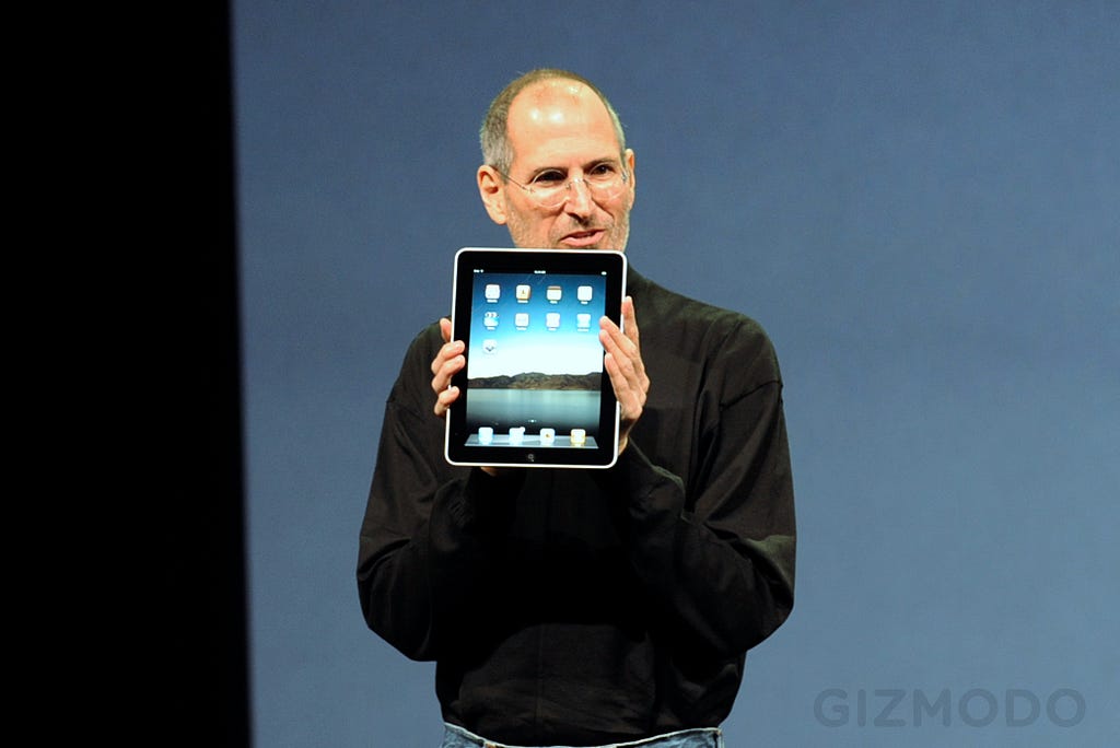 Photo of Steve Jobs holding up the first ipad on stage as he introduces it for the first time, January 2010.