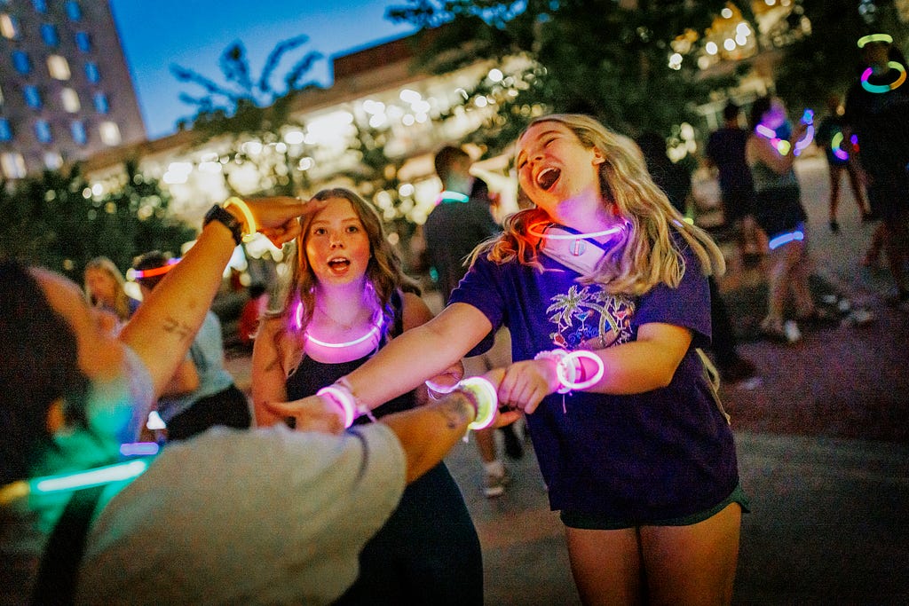 Lydia Hernandez smiles as she dances with her friends at the Harper Schramm Smith residence halls block party.