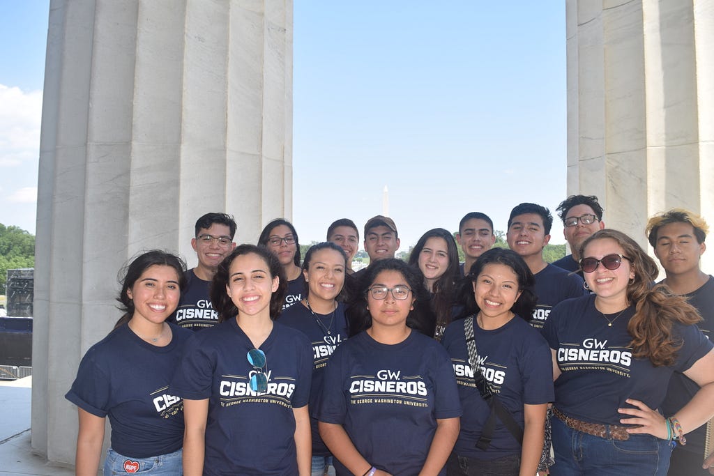 Fifteen students posing in the Lincoln Memorial