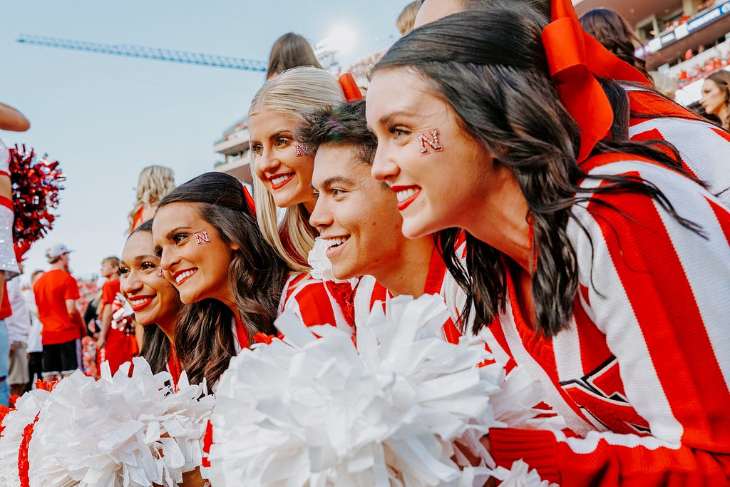 Logan, second from right, smiles for a photo with other Husker cheerleaders during the homecoming game.