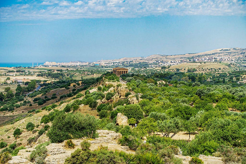 mediterranean valley with a hill in the center containing a greek temple