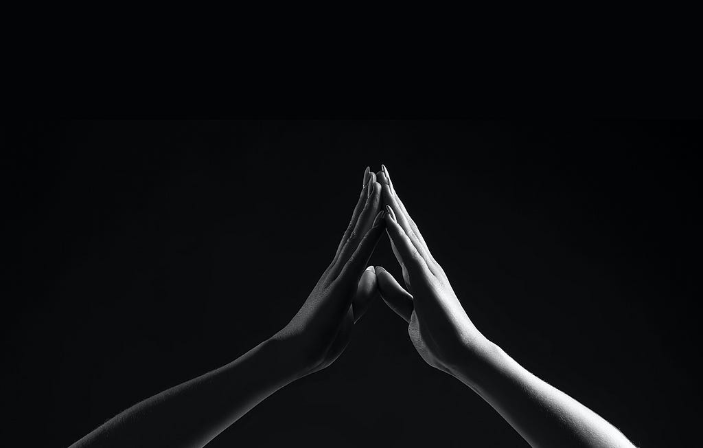 Black and white photo by Ricardo Gómez Angel via Unsplash. Two hands touching each other with the tips of the fingers.