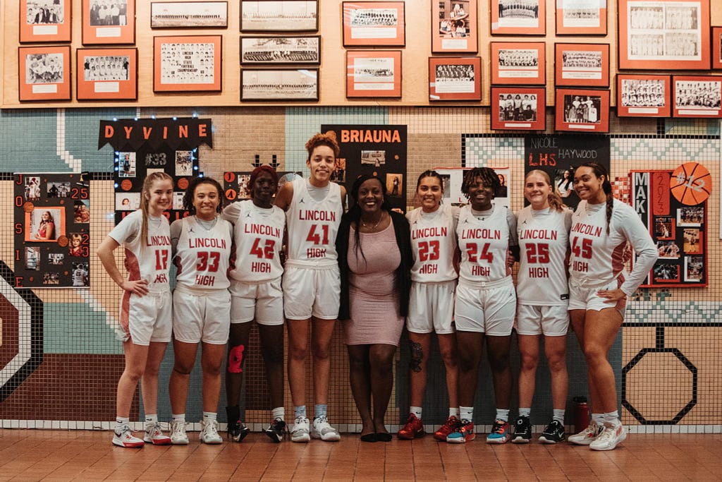 Dominique poses for a photo with her Lincoln High team