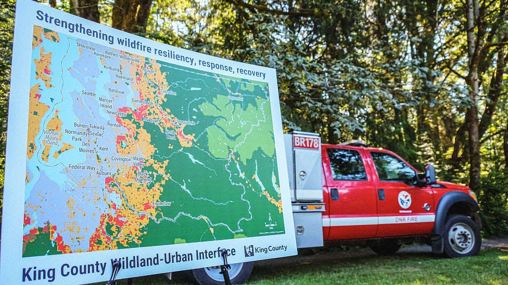 A county map on an easel in front of a fire department vehicle.