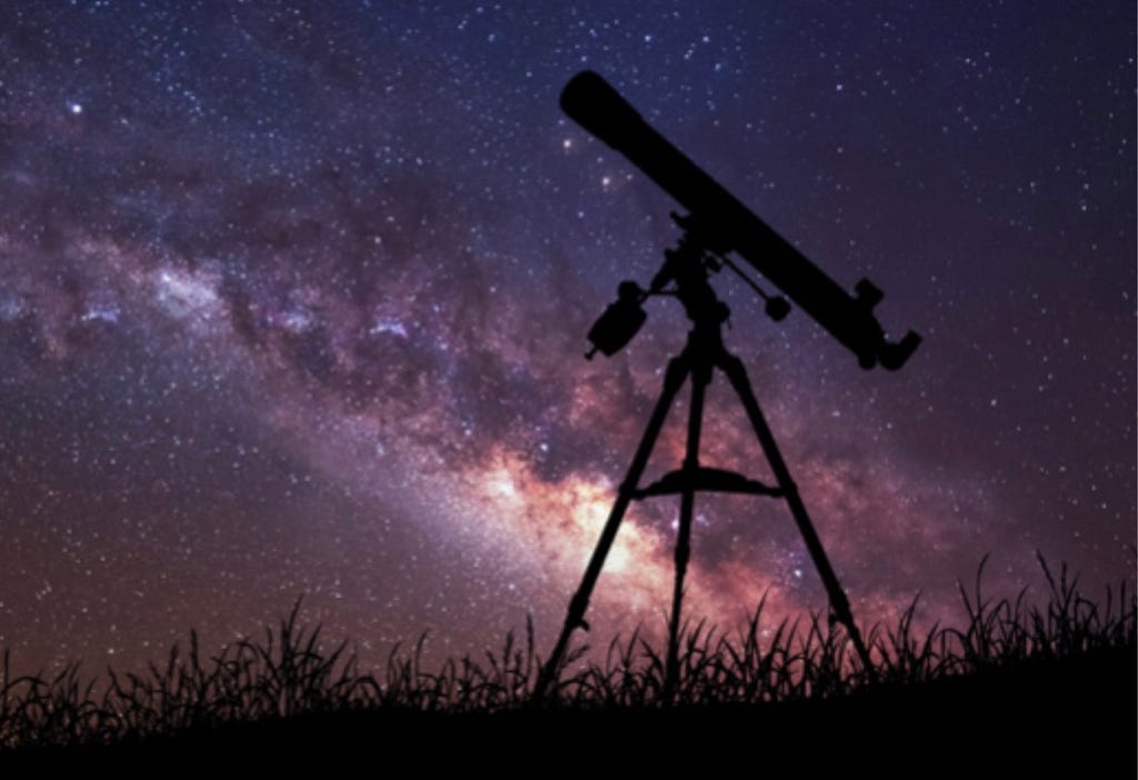 Telescope silhouetted against night sky.