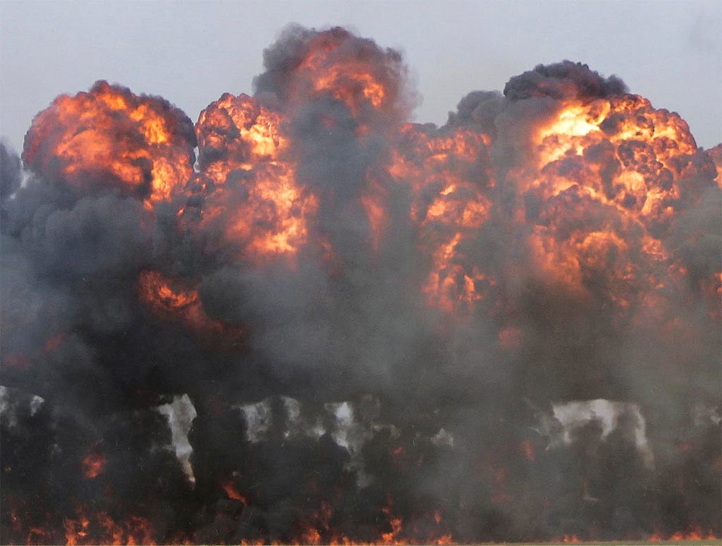 A photo of explosions and mushroom clouds