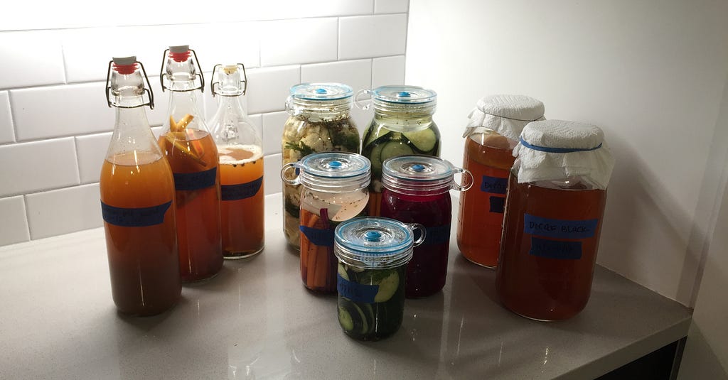 The pickle fleet in full force. Kombucha and pickled vegetables fermenting in jars.