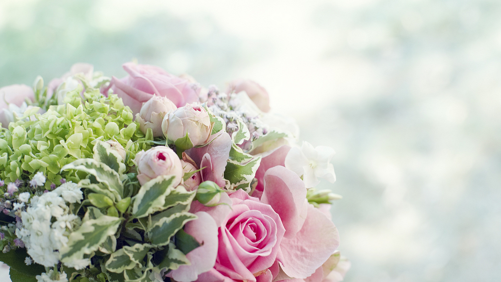 Flower bouquet with light pink roses and green foliage.