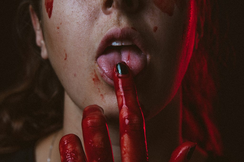 Someone is playing with blood, having a taste of it, and she wants more.