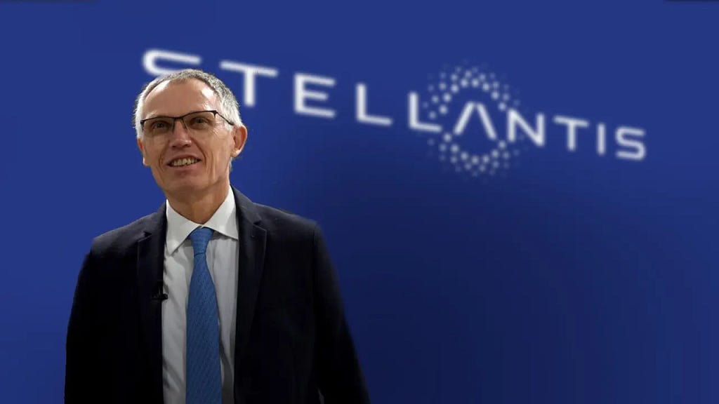 The CEO of Stellantis, Carlos Tavares, standing in front of a blue background with the Stellantis logo.