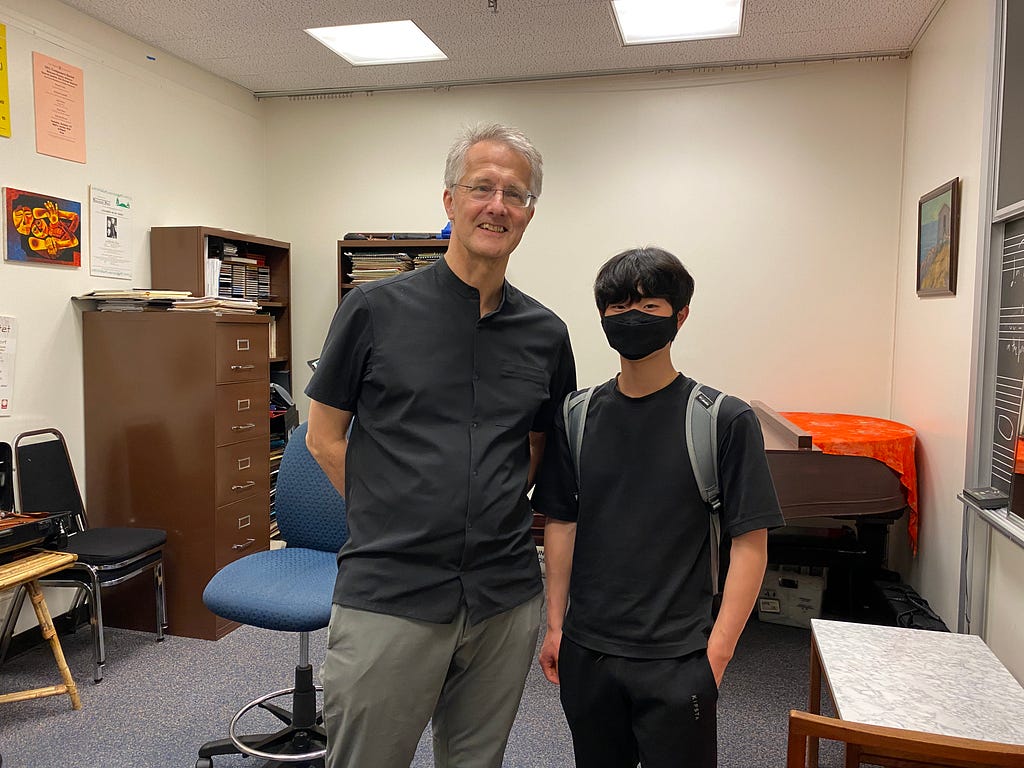 Tulio and his music teacher standing side by side