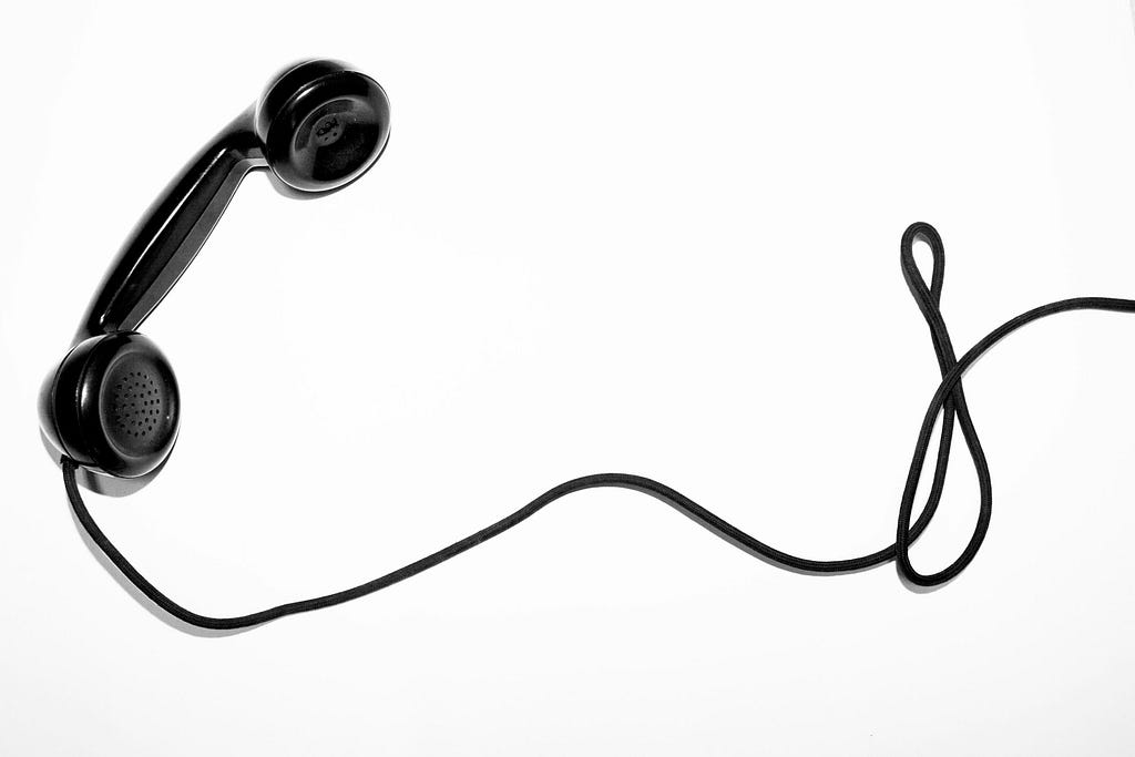 old black phone receiver and slack wire
