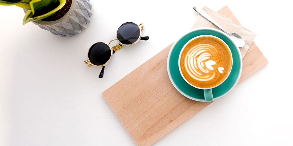 flat white specialty coffee next to sunglasses