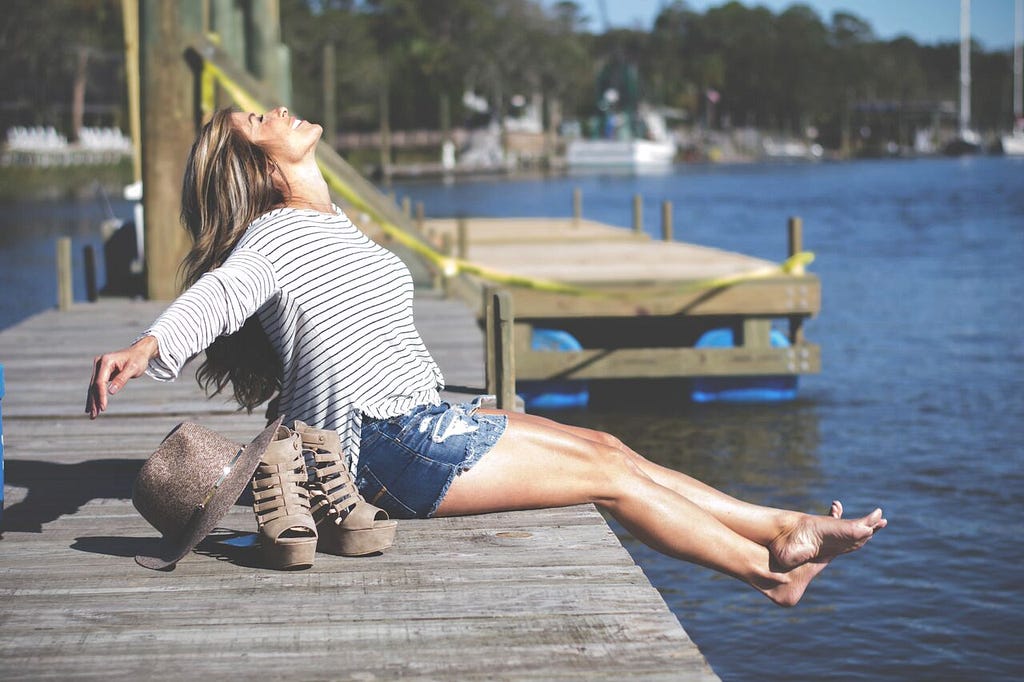 Christie stretched out on a pier, basking in the sunlight, looking free and happy.