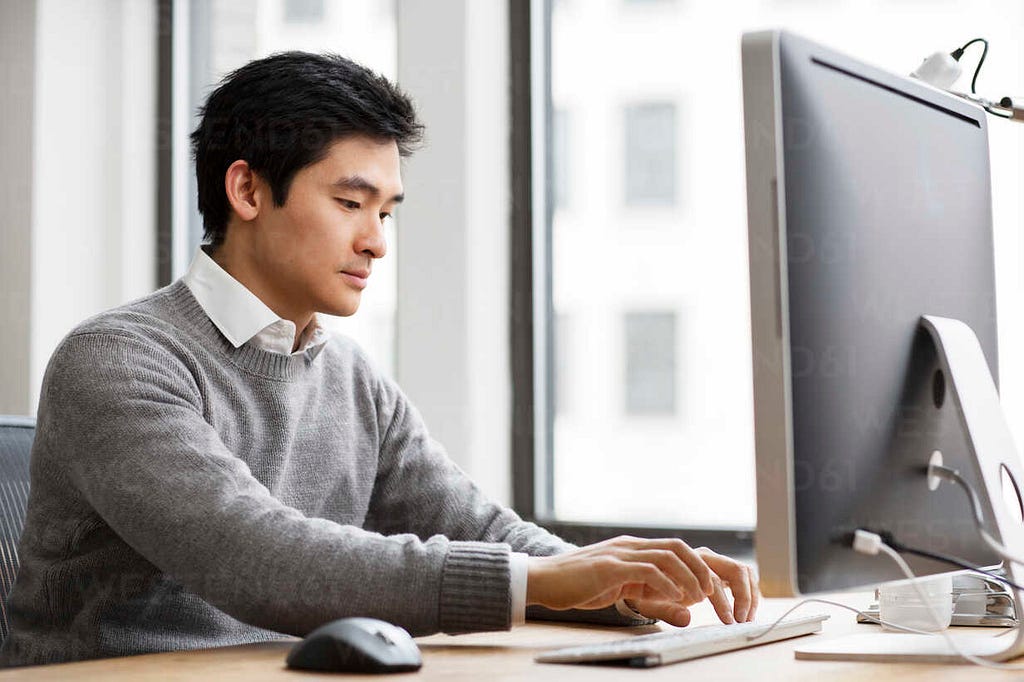 Man Researching on Computer the Average Pay of Life Insurance Professionals