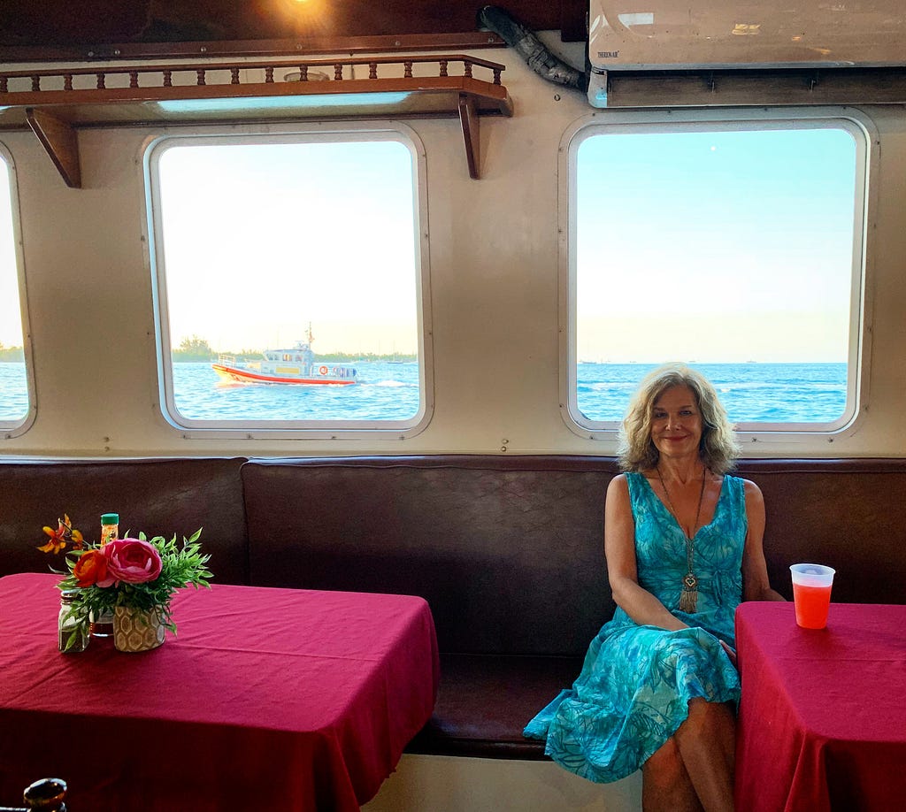 Author/musician M.E. law poses for a photo in her tropical sundress below deck in the galley.