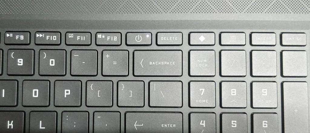 a photo of a laptop keyboard focusing on its power button.