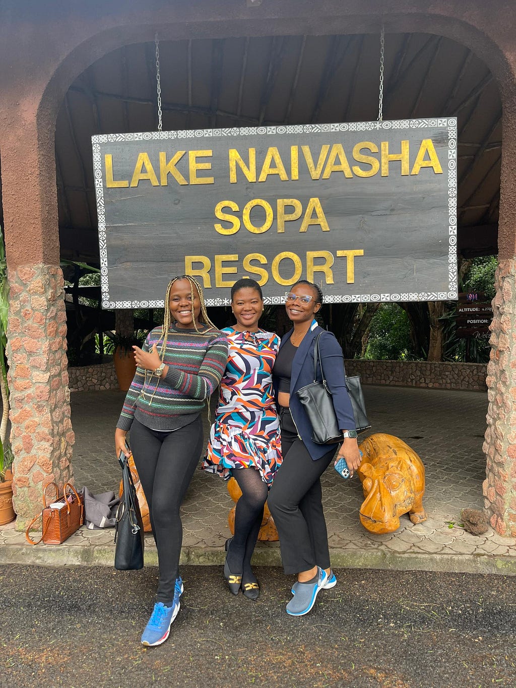 Mercy, Hope, and Ololade smiling wildly at the Lake Naivasha Sopa resort entrance