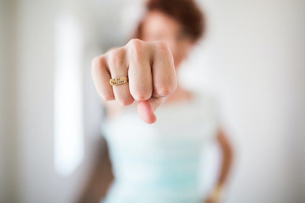 Woman in background, her fist in foreground.