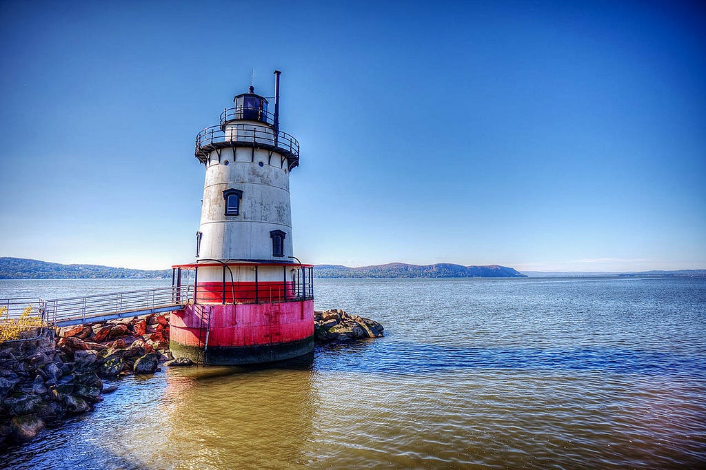 A historic lighthouse, Sleepy Hollow Lighthouse, stands tall on the Hudson River in New York.