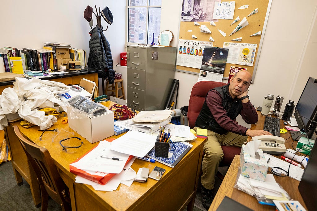 Aaron Thomas is pictured in his busy professor’s office.