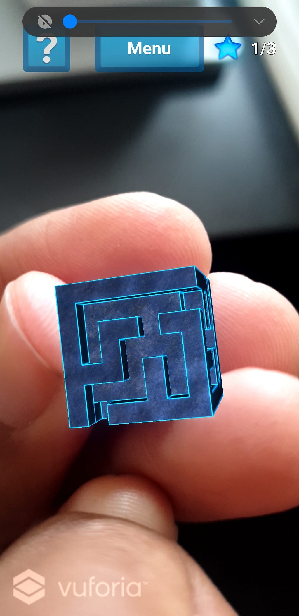 AR cube with a maze indented into it, held by hand