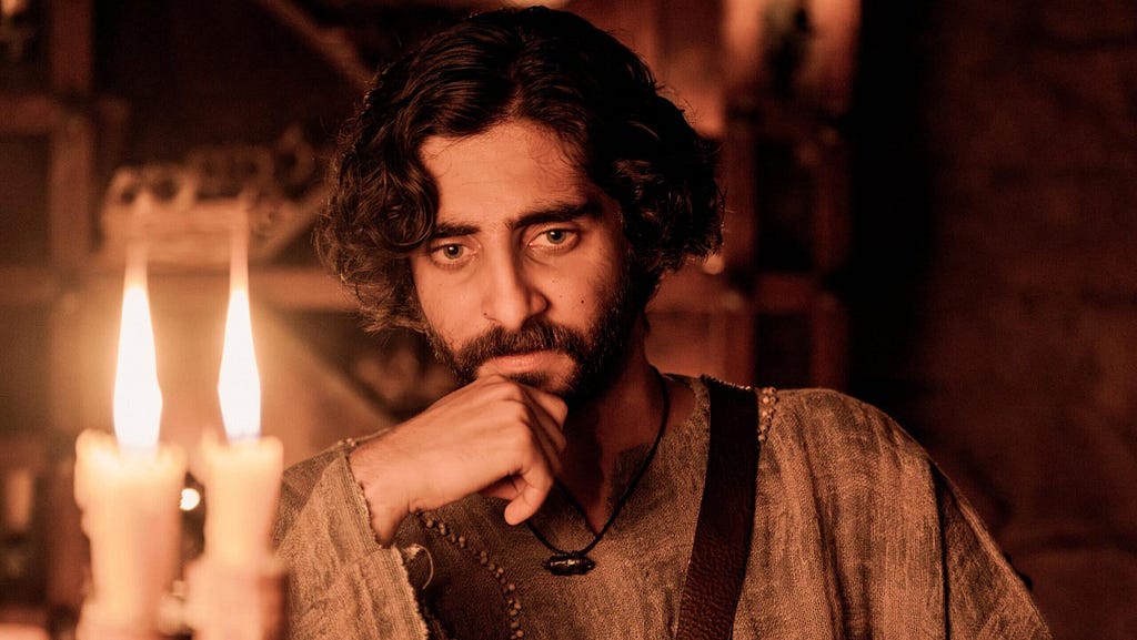 Judas, played by actor Luke Dimyon, holds a hand to his chin in a pensive pose before two candles in a scene from “The Chosen,”