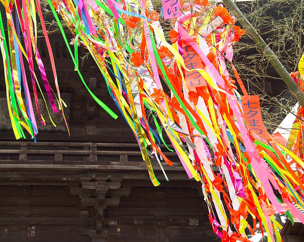Colorful paper streamers hang from bamboo branches.