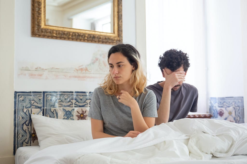 Unhappy couple sitting in bed