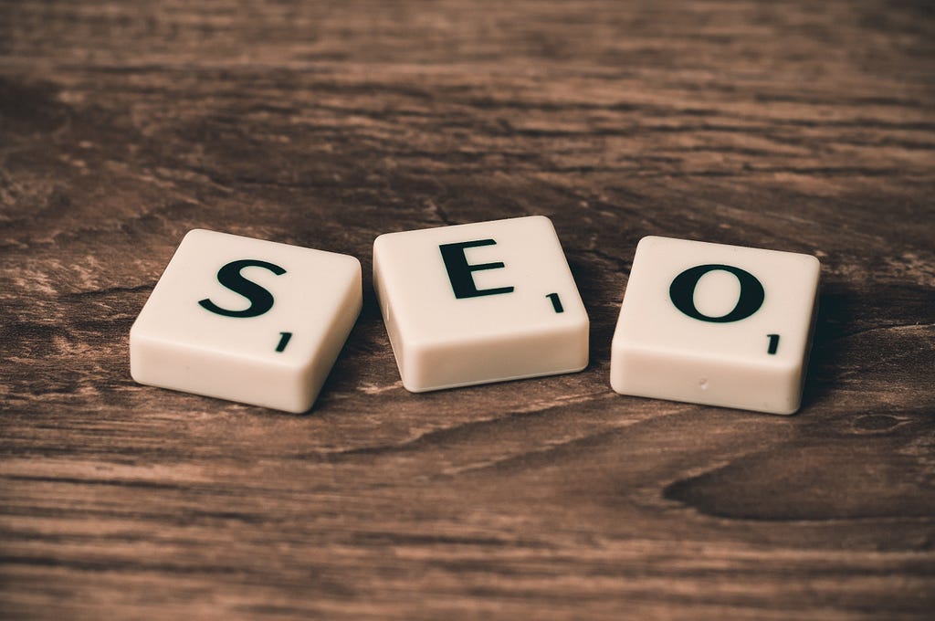 Scrabble  blocks spelling out “SEO” on a wooden table