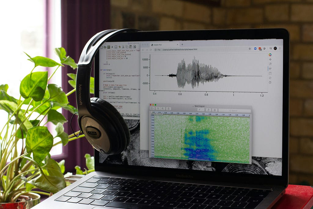 a laptop screen showcasing an audio waveform with a feature map.