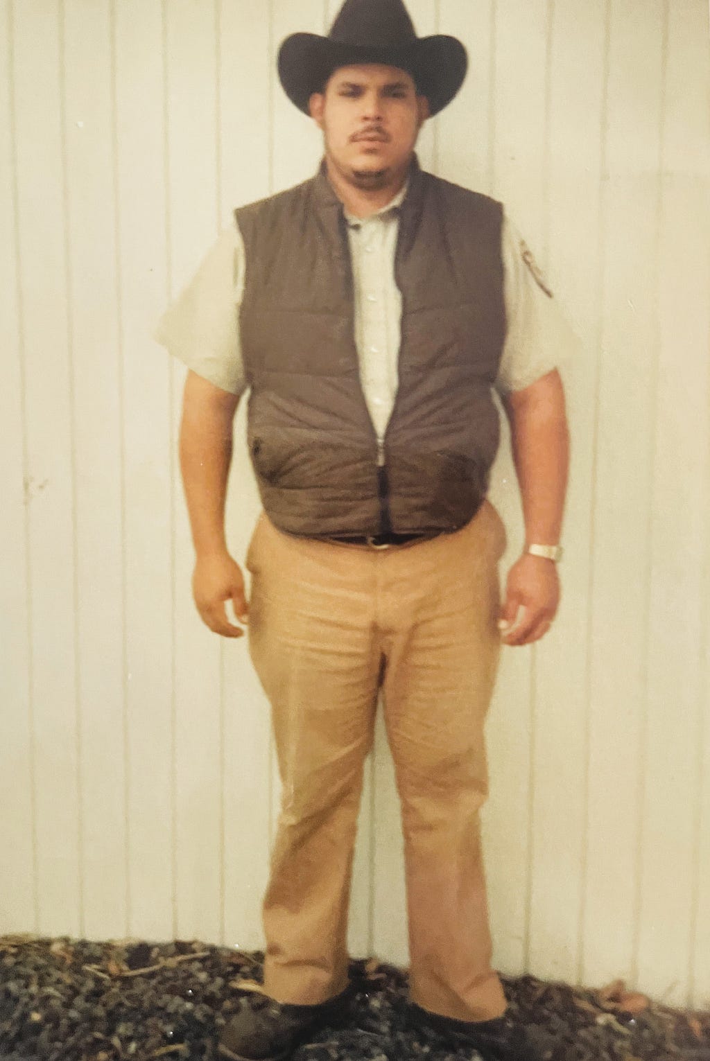 Robert Luna as a young man. He’s wearing a black cowboy hat, brown vest, and USFWS uniform.
