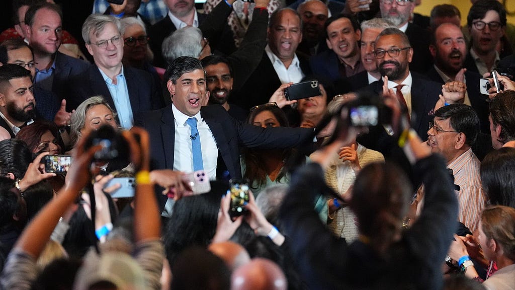 photo of Rishi Sunak greeting a crowd of supporters and press photographers
