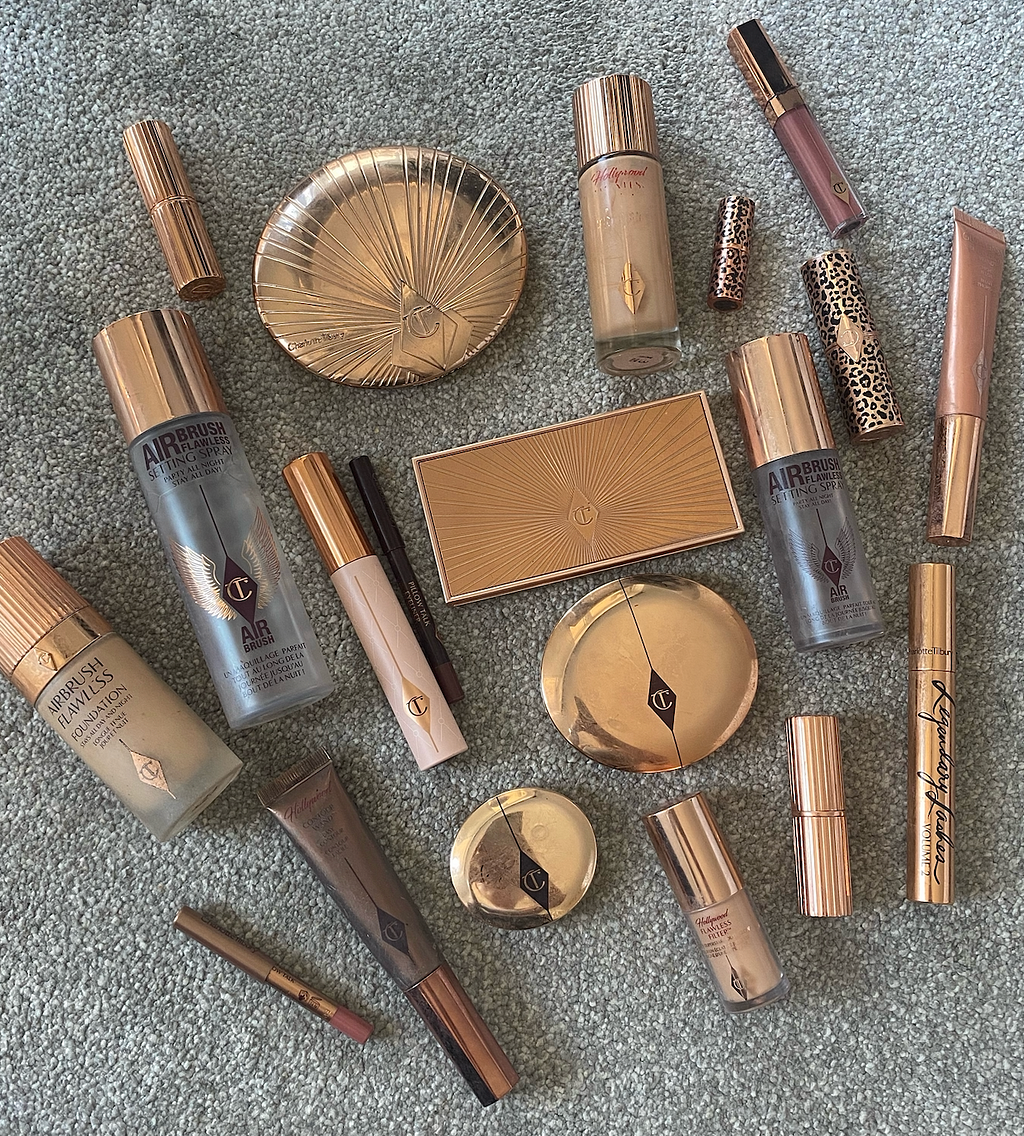 Image of Charlotte Tilbury products. All have gold packaging and a triangular ‘CT’ logo.