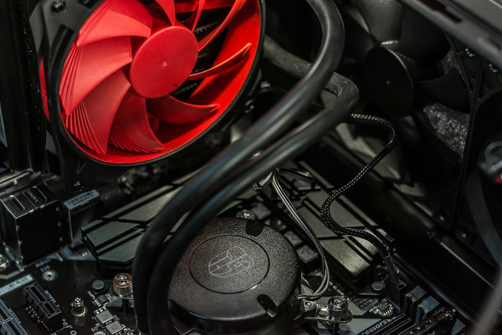 A red desktop PC fan inside a desktop machine with black internals.