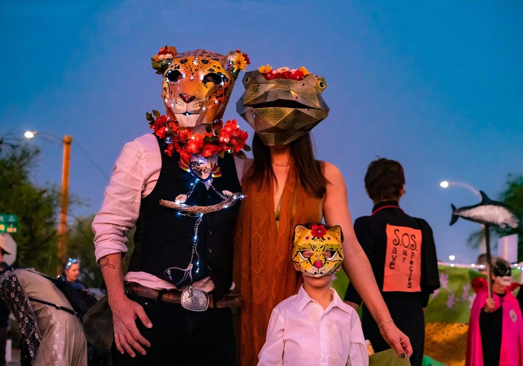 Family with masks of jaguar, Chiricahua leopard frog, and ocelot