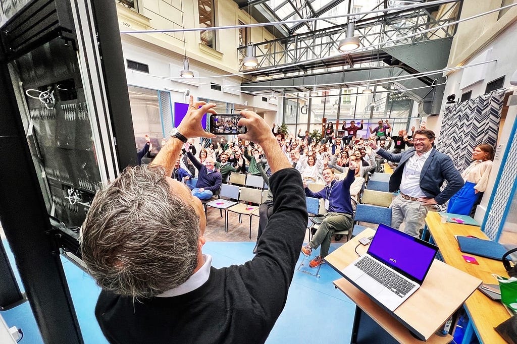 A person taking a group picture of a lot of people attending a team building event